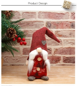 Detail eines handgefertigten roten Weihnachtszwergs mit Herz-Mütze und Holzknöpfen auf Tisch