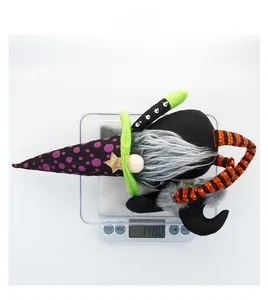 Détail d'un gnome d'Halloween avec chapeau à pois mauves posé sur une balance numérique