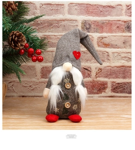 Nahaufnahme von Weihnachtsgnom mit grauem Herz-Hut und goldenem Schneeflocken-Mantel