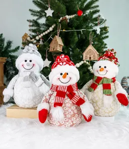 Three Christmas snowman figurines in various colors arranged by a festive tree