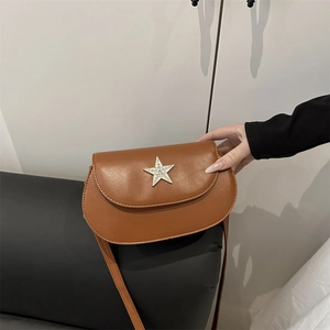Brown faux leather saddle bag with a large rhinestone star buckle and slim shoulder strap