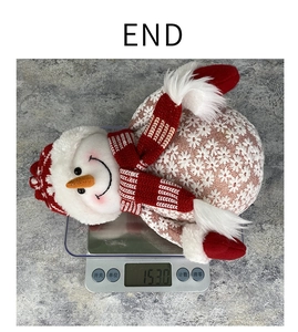 Detailed view of a Christmas plush snowman with knitted hat and scarf on a digital scale