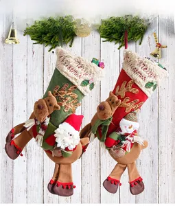 Detail of plush Christmas stockings with 3D Santa and snowman on white wood background