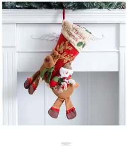 Detail of Christmas stocking featuring a 3D plush reindeer and snowman on a fireplace