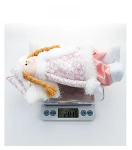 Detail view of a pink plush Christmas angel doll weighing 28.15g on a digital scale