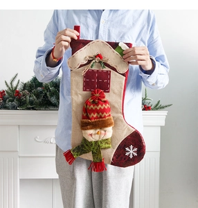 Detail of a large linen Christmas stocking with 3D snowman and house pattern