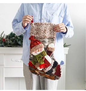 Detail of 3D snowman Christmas stocking held in hand with cozy fireplace background