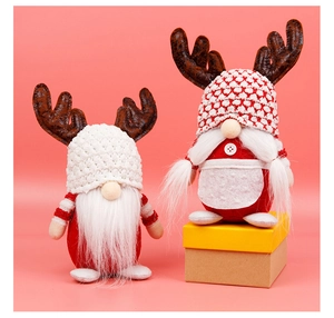 Detail van kerstkabouters met gebreide mutsen en rendiergewei op roze achtergrond