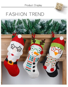 Détail de trois chaussettes de Noël suspendues avec motifs Père Noël, Bonhomme de neige et Pingouin