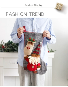 Detail of knitted Christmas stocking featuring a 3D Santa doll and rustic burlap mini bag