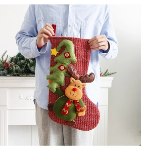 Knitted Christmas stocking with 3D reindeer and green tree on a red background
