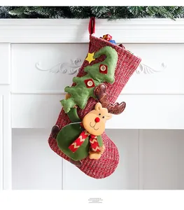Detail of red knit Christmas stocking with reindeer and tree on white fireplace