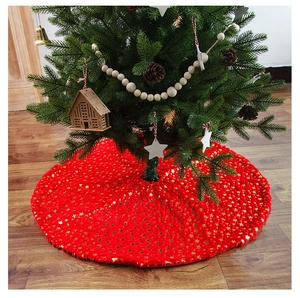 Detail of red plush Christmas tree skirt featuring shiny gold star patterns on floor