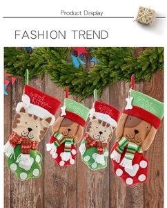 Detail von Weihnachts-Haustiersocken mit Katzen- und Hundepfoten auf Holzwand