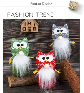 Detailed view of three owl plush dolls in red, green, and gray on a wooden surface