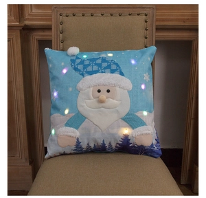 Close-up of blue Christmas pillow cover with LED lights and Santa Claus embroidery