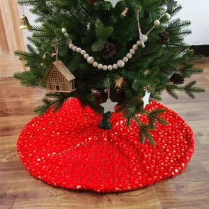 Red plush Christmas tree skirt with gold star patterns on a wooden floor