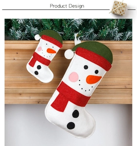 Detail of two felt snowman Christmas stockings hanging on a wooden fireplace mantle