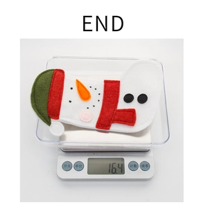 Detailed view of handmade felt snowman Christmas decoration weighing 16.4g on a scale