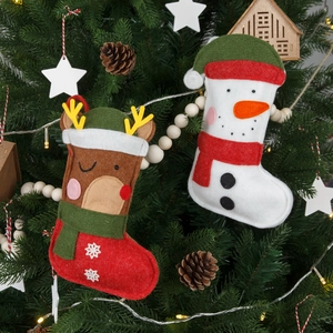 Christmas felt stockings featuring reindeer and snowman designs hanging on a festive tree