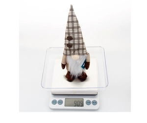 Detail showing the coffee-themed gnome plush weight of 90.9g on a digital scale