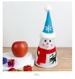 Detailed view of a felt snowman decoration with blue hat and red scarf on a wood table
