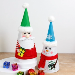 Festive Santa and Snowman fabric figurines on white platform with Christmas ornaments