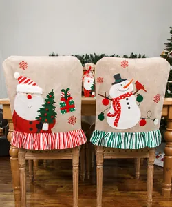 Détail de housses de chaise de Noël en lin brodé avec motifs Père Noël et bonhomme de neige