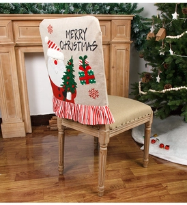 Macro detail of burlap Christmas chair cover featuring Santa Claus and striped pleated hem