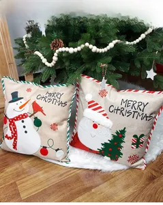 Linen Christmas pillow covers with Santa and Snowman embroidery on a white faux fur rug