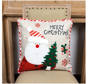 Detail of Christmas pillow cover with Santa embroidery and red white striped piping