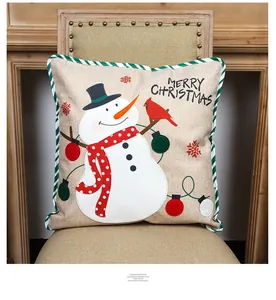 Detail of Christmas snowman embroidery on linen pillowcase with green striped piping