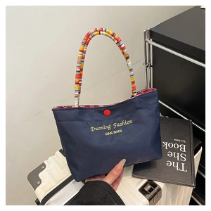 Detail der blauen Segeltuch-Tasche mit Seilgriff und rotem Knopfverschluss