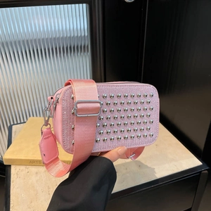 Pink rhinestone crossbody camera bag with metal studs and wide nylon shoulder strap