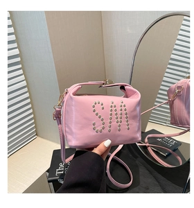 Détail du sac cabas rose en cuir avec lettrage SM en clous et finitions dorées chic