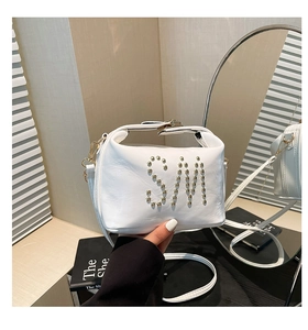 Détail du sac cabas blanc en similicuir avec logo SM en rivets dorés et bandoulières