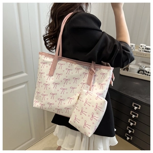 Detail view of white canvas tote bag with pink bow heart prints and small matching pouch