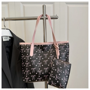 Detail of black tote bag set with pink bow pattern and matching mini hanging purse