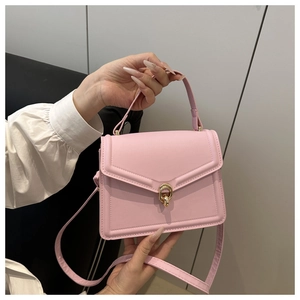 Detailed view of pink textured leather crossbody bag with elegant gold twist lock closure