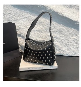 Detail of silver rivets on black lychee grain leather motor bag with stylish studs