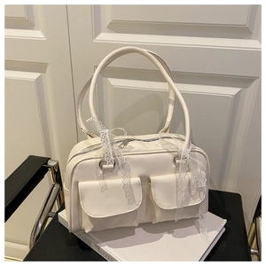 Detail of off-white PU leather pillow bag featuring lace ribbons and double flap pockets