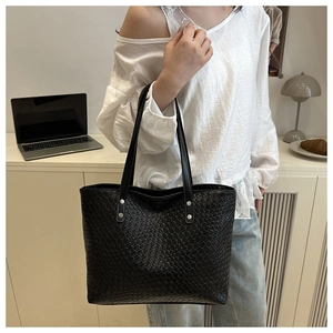 Close-up of black woven texture tote bag with large capacity and silver rivet details