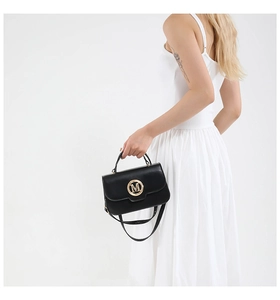 Detail of black matte leather handbag featuring a gold metallic M logo and slim strap