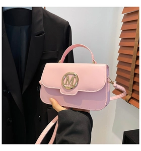 Detailed shot of pink leather mini square bag with golden letter M hardware and handle