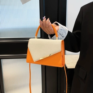 Chic orange and beige crossbody bag with gold metal trim and curved handle