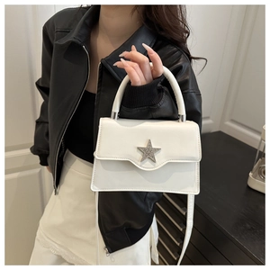 Détail du petit sac blanc carré avec étoile en strass porté par le mannequin