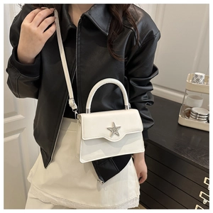 Gros plan du sac bandoulière blanc avec étoile en strass et poignée en cuir chic