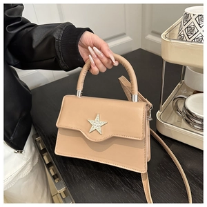 Détail du sac carré beige orné d'une grande décoration étoile en strass scintillants