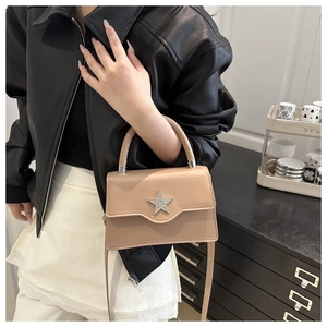 Détail du sac carré beige avec boucle étoile scintillante et texture en cuir