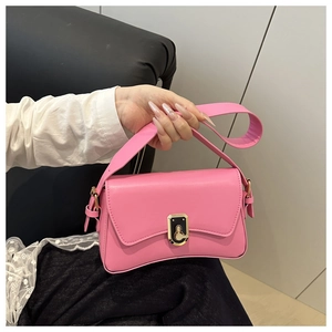 Detail shot of a pink crossbody bag featuring a golden metallic twist lock and wide strap